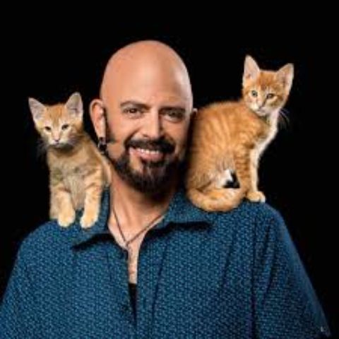 Jackson Galaxy in the picture with two cats on his solders.